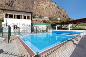 a swimming pool in front of a house with a mountain at Vivienda Vacacional Risco Blanco in San Bartolomé