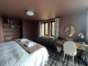 een slaapkamer met een bed, een bureau en een spiegel bij Couples retreat Boutique style Barn conversion in Great Yarmouth