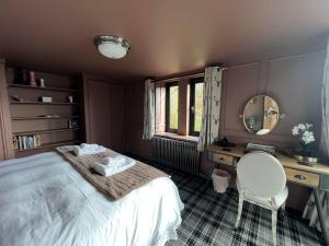 ein Schlafzimmer mit einem Bett, einem Schreibtisch und einem Spiegel in der Unterkunft Boutique Barn - Sleeps 4 Parking & Private Garden in Great Yarmouth