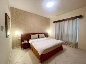 a bedroom with a large bed and a window at Lovely 2BR Al Deyafa in Dubai