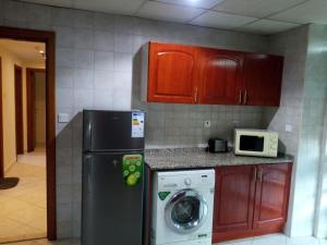 a kitchen with a refrigerator and a washing machine at Lovely 2BR Al Deyafa in Dubai
