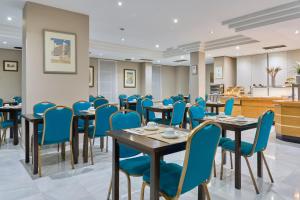 a dining room with tables and blue chairs at Porcel Navas in Granada