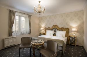 a bedroom with a bed and two chairs and a chandelier at Château Šanov in Šanov