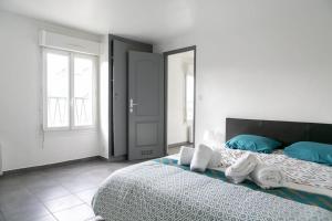 ein Schlafzimmer mit einem großen Bett mit Handtüchern darauf in der Unterkunft Appart Hotel - Calme et Cosy in Montereau-faut-Yonne