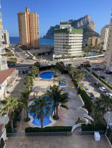 uitzicht op een stad met palmbomen en gebouwen bij Esmeralda Suites in Calpe