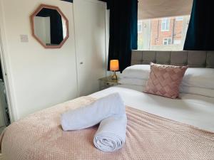 um quarto com uma cama com uma toalha em A modern cosy one bedroom home away from home em Houghton le Spring