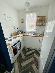a kitchen with a white stove and a sink at A modern cosy one bedroom home away from home in Houghton le Spring