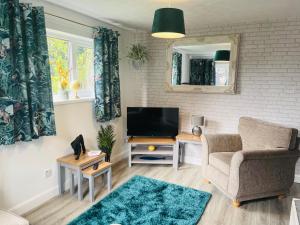 a living room with a television and a chair at A modern cosy one bedroom home away from home in Houghton le Spring