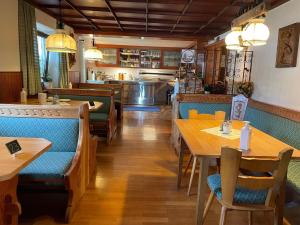um restaurante com mesas de madeira e assentos azuis em Gästehaus Stefanie em Schwangau