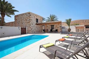 a villa with a swimming pool next to a house at Casa Rural Andresito in Pájara