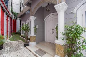 a white front door of a house with white columns at RedDoorz At Ralica Grand Palladium Medan in Medan