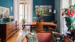 een eetkamer met blauwe muren en een houten tafel bij Maison et studio l'Orangerie in Rome