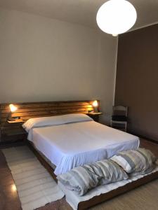sypialnia z białym łóżkiem z drewnianym zagłówkiem w obiekcie Villa delle Stelle w mieście Cassaro