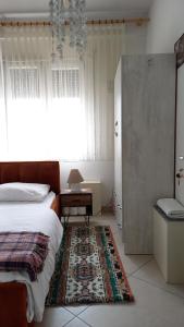 een slaapkamer met een bed, een raam en een tapijt bij Isabel's B&B in Tirana