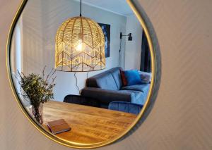 ein Spiegel, der ein Wohnzimmer mit einem Sofa und einem Tisch reflektiert in der Unterkunft Lodge Koolmees Nunspeet Veluwe in Nunspeet