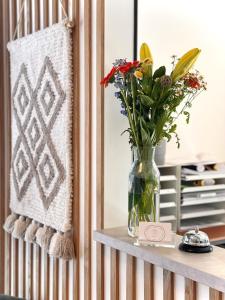 a vase of flowers on a table with a rug at Arbio I Urbanstay Serviced Studios & Apartments in Graz