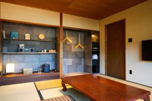 a living room with a wooden table and a tv at Ryokan Oomuraya in Ureshino