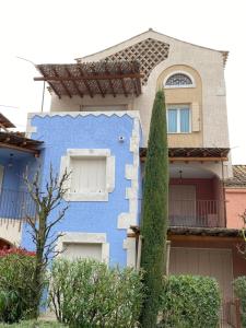 una casa azul con un árbol delante en Cascina Jesolana, en Lido di Jesolo