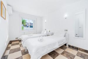 two beds in a white room with a window at Entire Large Villa next to Award-winning beach in Campoamor