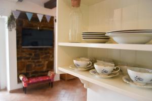 a kitchen with cups and plates on a shelf at Villa Carla - Istrian house in Koper