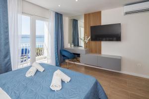Habitación de hotel con cama y TV de pantalla plana. en Skalinada Sea View en Lokva Rogoznica