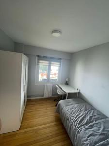 um quarto com uma cama, uma secretária e uma janela em Vibes Coruña-Paz 16 em Culleredo
