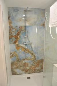 y baño con ducha y una pintura en la pared. en Westin House Resort Kołobrzeg Apartament DELUX en Kołobrzeg