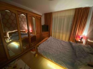 ein Schlafzimmer mit einem Bett und einem großen Spiegel in der Unterkunft Cozy & complete 3 room flat in Brăila