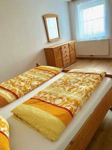 1 Schlafzimmer mit 2 Betten und einem Wandspiegel in der Unterkunft Steirer Haus in Gamlitz