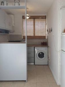 uma cozinha com uma máquina de lavar roupa e uma máquina de lavar roupa em Cosy studio overlooking Porto Germeno gulf em Aigósthena