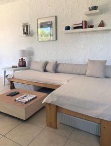 uma sala de estar com um sofá e uma mesa em Cosy studio overlooking Porto Germeno gulf em Aigósthena