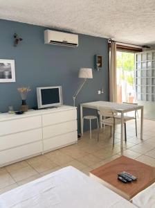 uma sala de estar com uma mesa e uma televisão em Cosy studio overlooking Porto Germeno gulf em Aigósthena