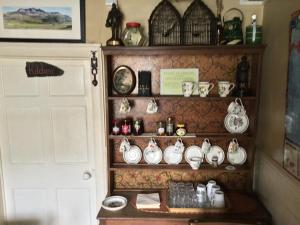 a shelf filled with lots of tea pots and clocks at Ty Seren in Dolgellau