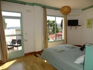 a bedroom with a bed and a balcony at Casa Alestelou in Tormos