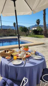 a table with a blue table cloth with food on it at Casa Alestelou in Tormos