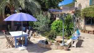a patio with a table and an umbrella and chairs at Casa Alestelou in Tormos