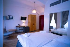 a bedroom with two beds and a desk and a tv at Hotel PAYER II in Teplice