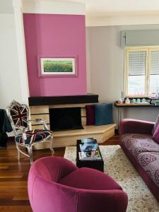 uma sala de estar com paredes roxas e uma lareira em La scala del libro em Santo Stefano di Rogliano