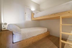 um quarto com 2 beliches e uma escada em Alta House Apartments Sa Blava em Begur