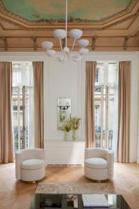 a living room with two chairs and a ceiling at Maison Delano Paris in Paris