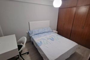 ein kleines Schlafzimmer mit einem Bett und einem Schreibtisch in der Unterkunft VibesCoruña- San Rosendo 25 in A Coruña