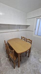 einen Holztisch und Stühle in einem Zimmer in der Unterkunft VibesCoruña- San Rosendo 25 in A Coruña