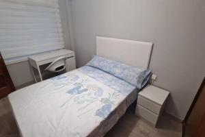 ein kleines Schlafzimmer mit einem Bett und einem Schreibtisch in der Unterkunft VibesCoruña- San Rosendo 25 in A Coruña