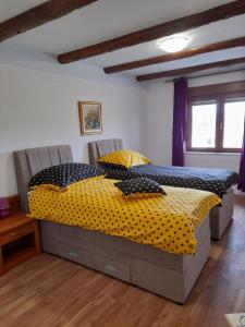 ein Schlafzimmer mit einem großen Bett mit Polka-Punkten-Bettwäsche in der Unterkunft Bed and Breakfast Lovac in Kaldanija