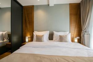 a bedroom with a large bed with white sheets and pillows at MM Central luxury in Kolašin