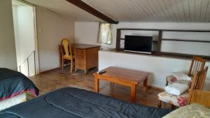 1 dormitorio con 1 cama y escritorio con TV en Duplex en el centro de Concepción del Uruguay en Concepción del Uruguay
