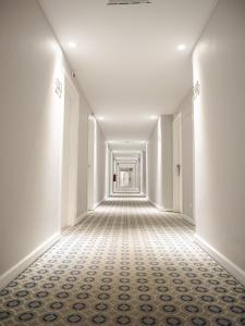 an empty hallway with white walls and tile floors at Hotel Baia in Cascais