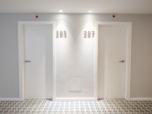 two doors in a room with numbers on the wall at Hotel Baia in Cascais