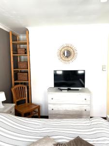 een slaapkamer met een bed en een dressoir met een tv bij Chez’ Elle in Blankenberge