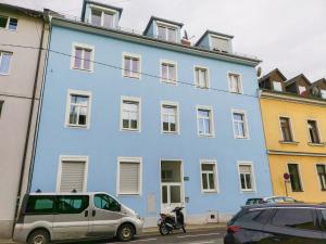 a blue building with cars parked in front of it at surf.Lend in Graz